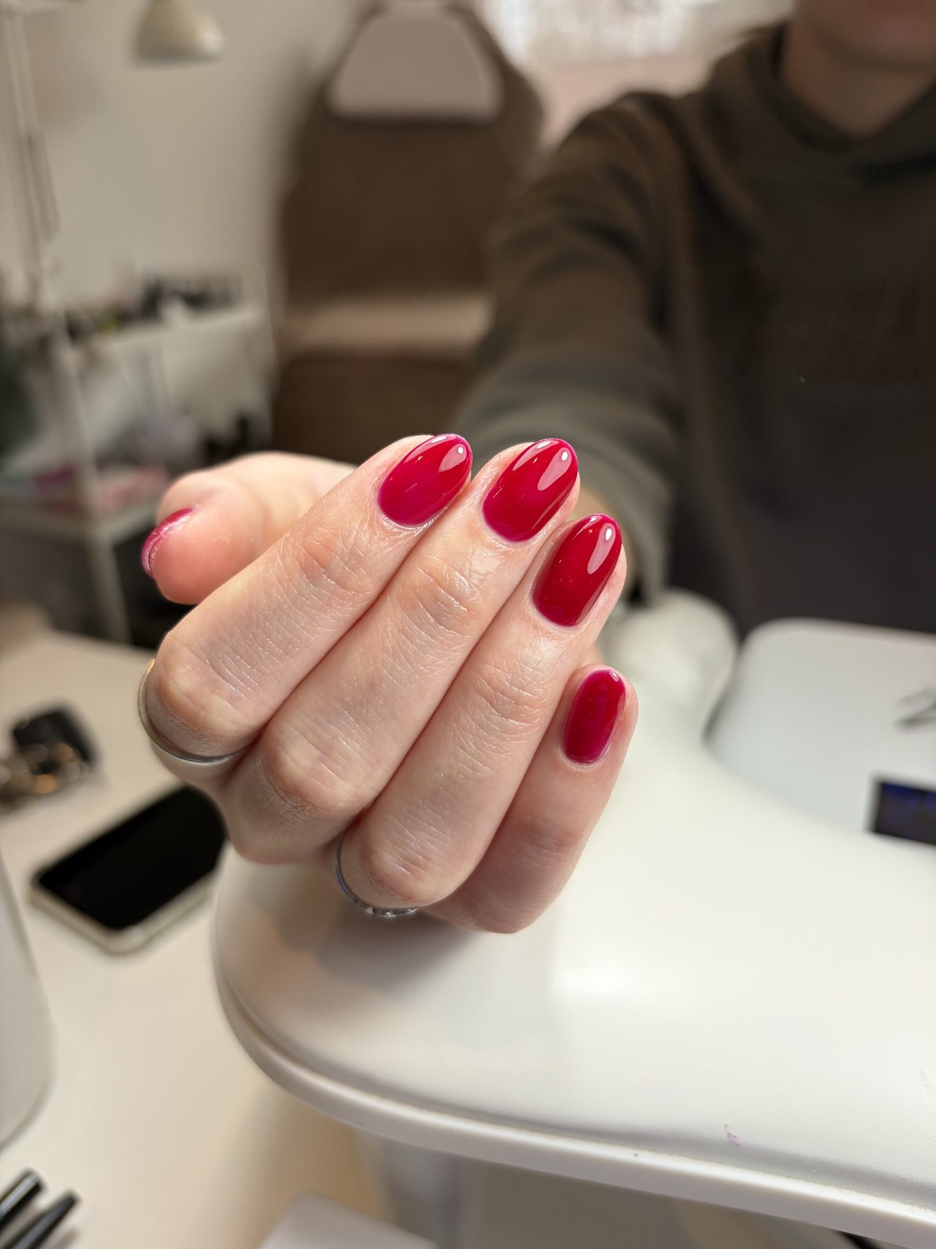 Rode nagels boven de nagellamp in de salon