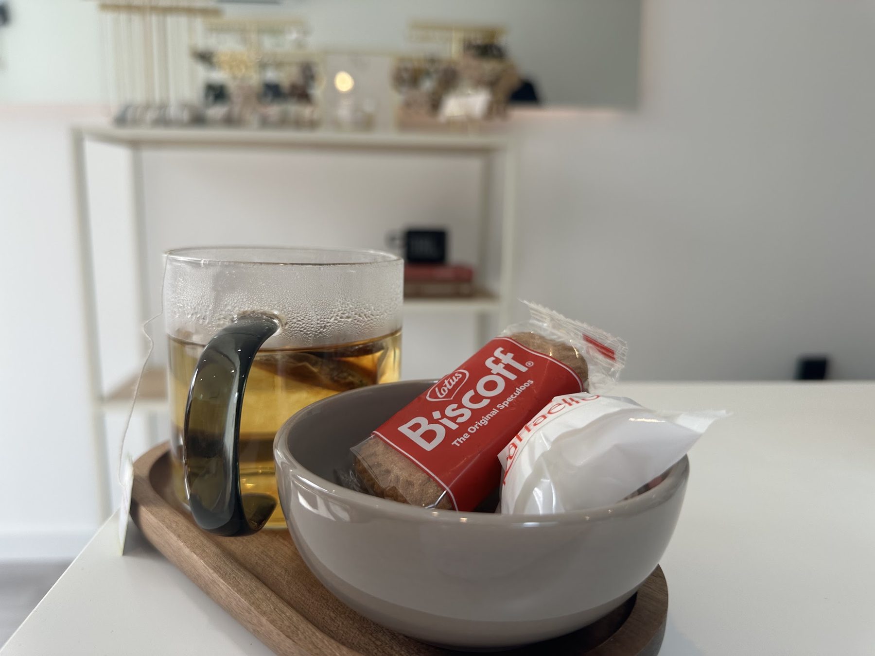 Een glas thee met een Biscoff-koekje op de tafel in de salon