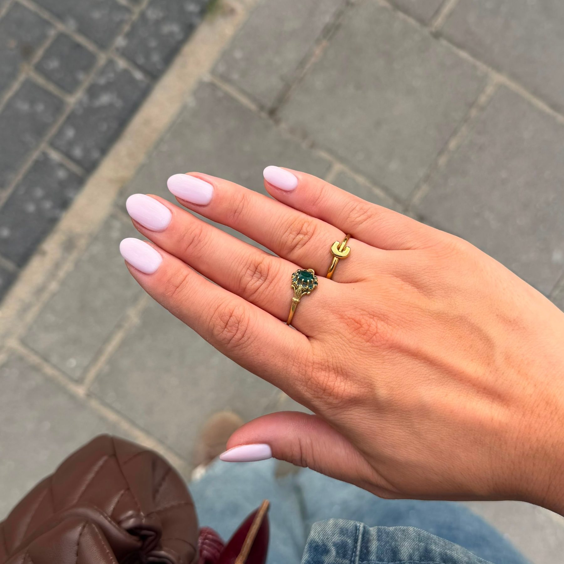 Lila-roze BIAB-nagels buiten in het daglicht